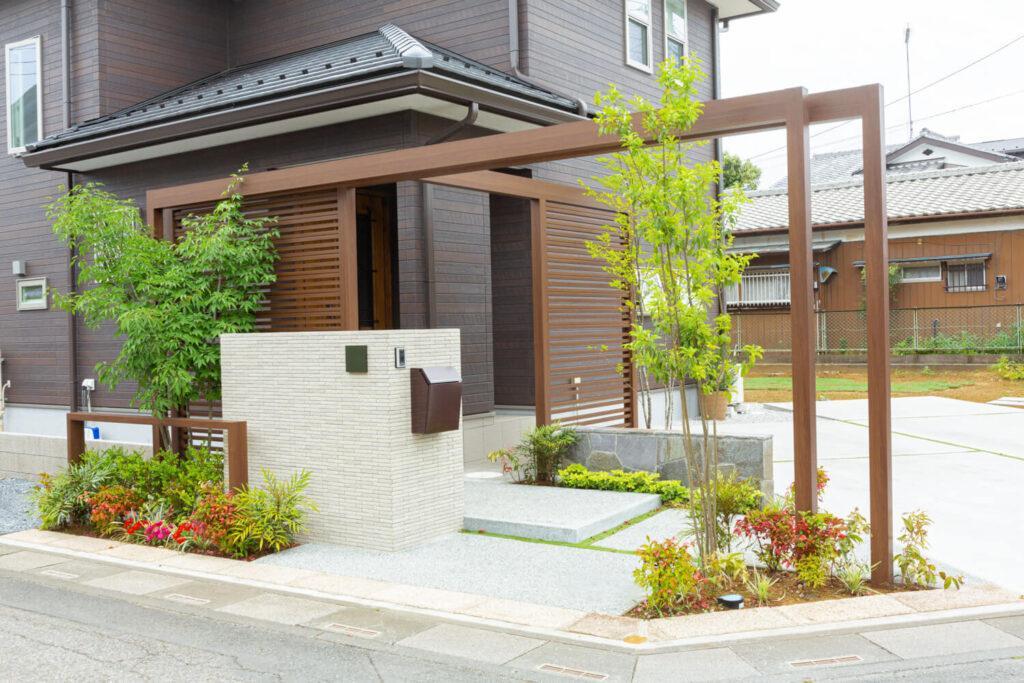 木調目隠しフェンスに植栽が彩りを添える隅切り角地の施工例（北本市） | 川越の外構・エクステリアは全国トップレベルの受賞歴を誇るアークふくしまへ