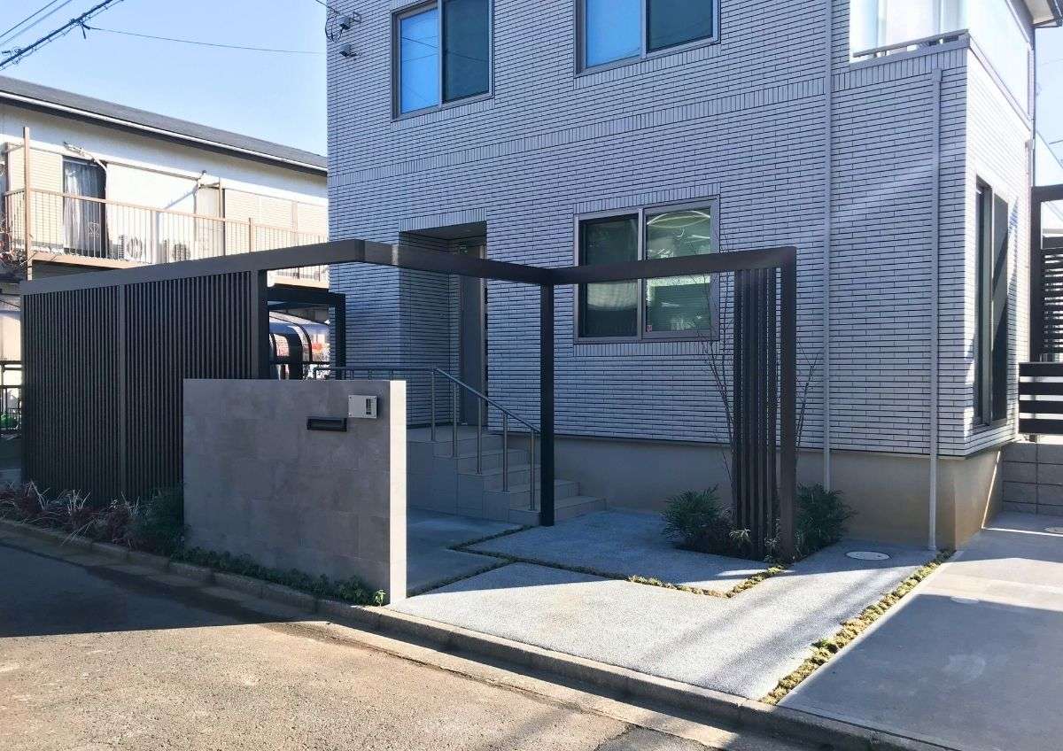 一条工務店の建物に調和する、LIXILプラスGのL字フレームと大判タイル門柱を組み合わせた高級感ある新築外構全景