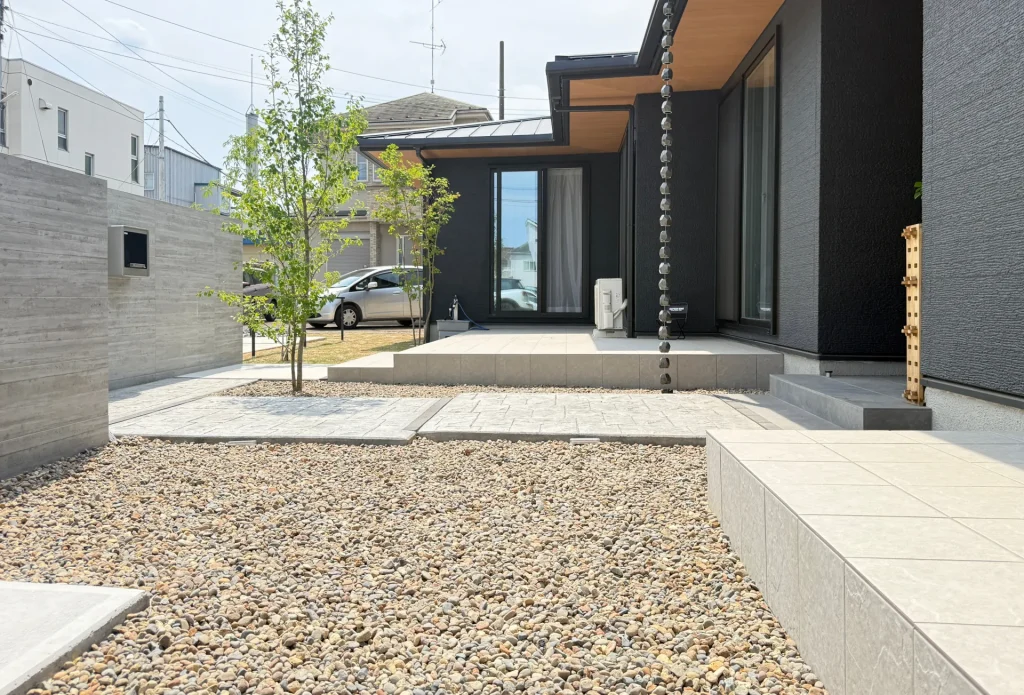 川越市の新築外構・スタンプコンクリートのアプローチ周りに敷いた化粧砂利。あたたかみのある外観とローメンテナンスを両立した庭まわりの仕上げ。