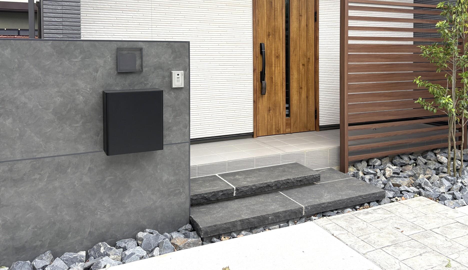 エスビックのソレアードグランデを使用した高級感のある浮き階段とゴロタ石の足元装飾