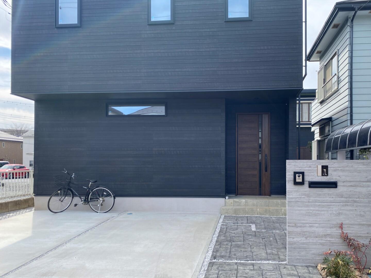 スタンプコンクリ－トのアプロ－チと木目調タイルの門柱がおしゃれな