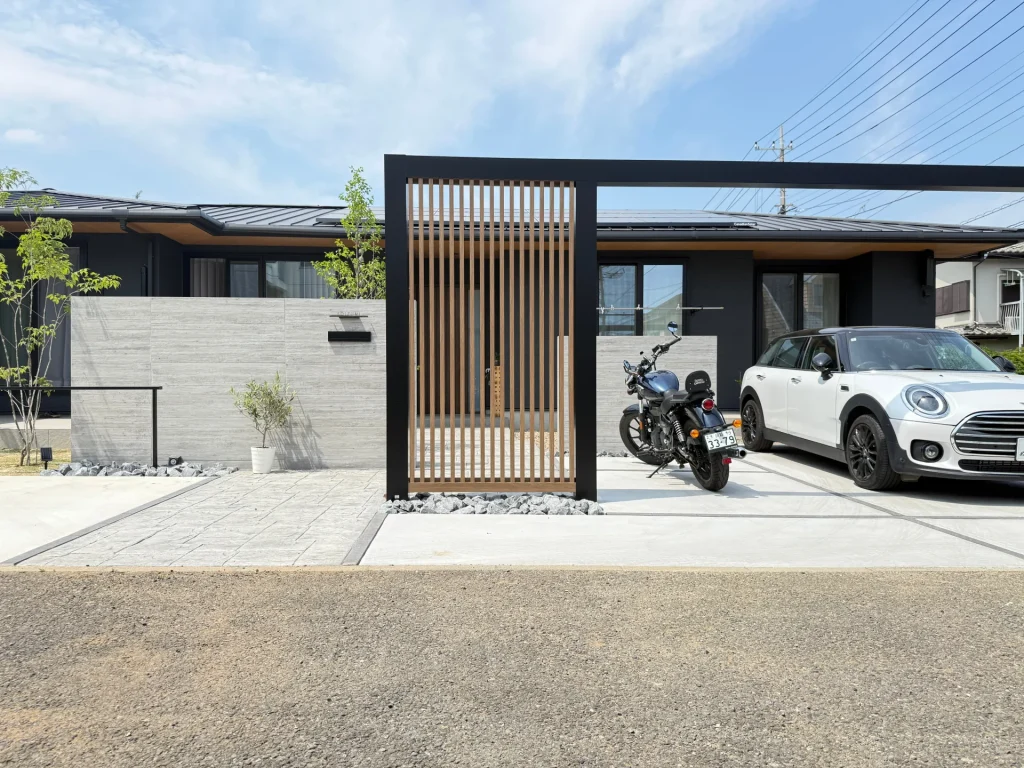 川越市の新築外構・LIXILプラスGのゲートと縦格子で仕切った車庫スペース。大判タイル門塀と調和した開放感のあるデザイン。