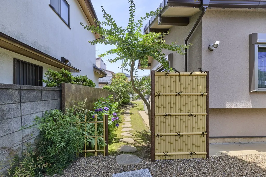 リビングから望む中庭。植栽の後ろにタカショーアートボードで目隠し