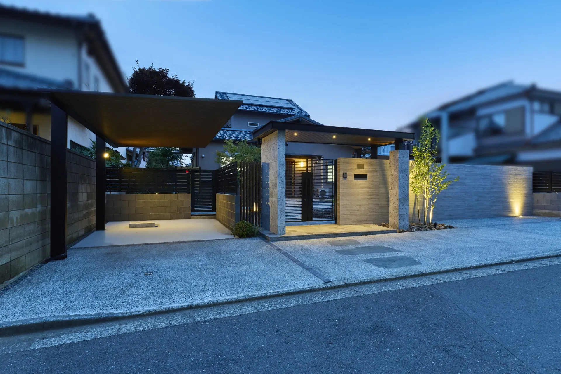 アーチ屋根のダウンライトと植栽灯に照らされた夜の門まわり