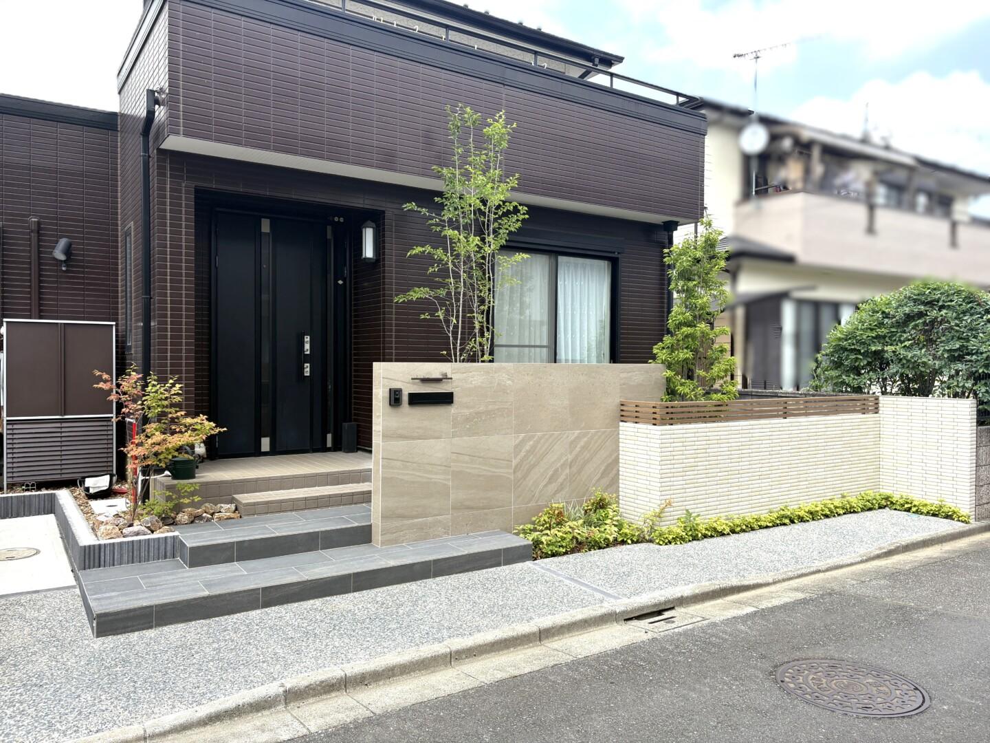 自然石調大判タイルを使った高級感ある門柱と低段差のタイル階段がある外構リフォーム全景