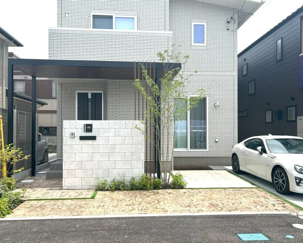 建物のタイルに合わせたグレーの自然石調大判タイルを使用した高級感のある門塀