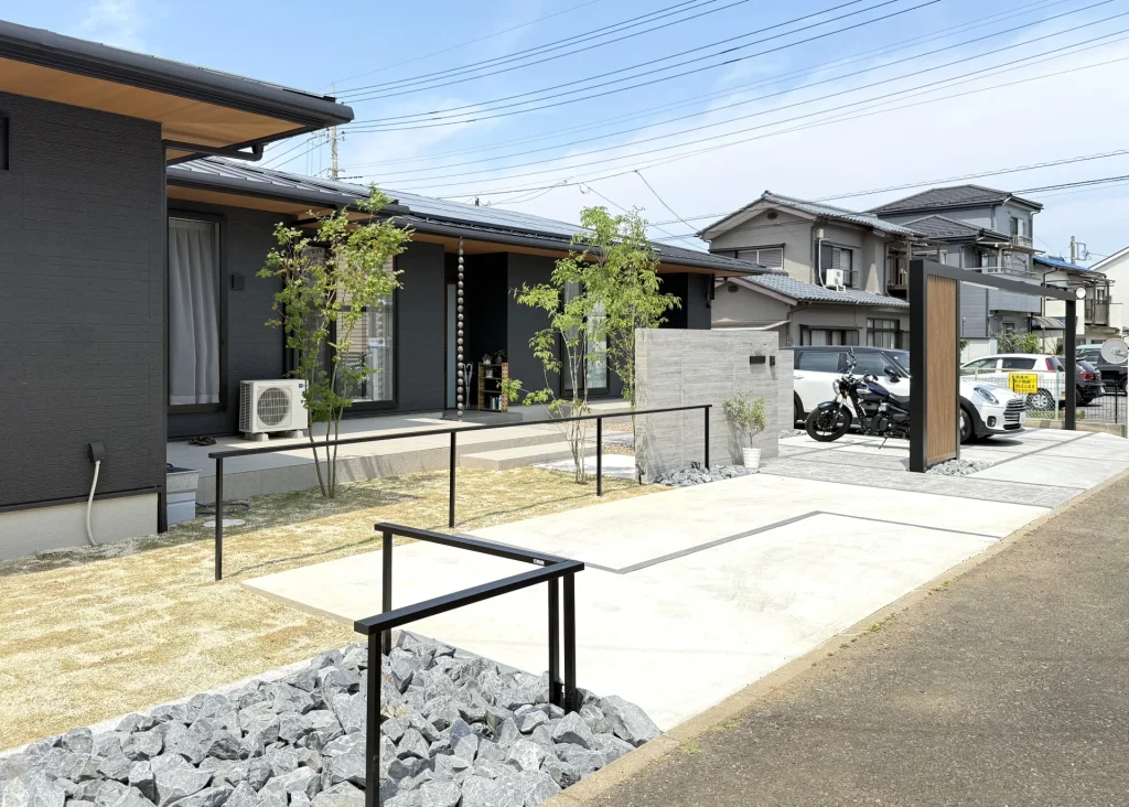 川越市の平屋新築住宅・外構工事完成後の全景。大判タイル門塀とプラスG、天然芝と化粧砂利が調和したオープン外構。
